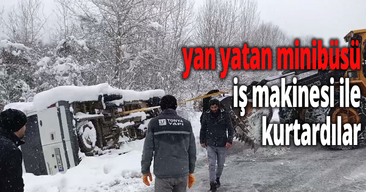 Karlı yolda yan yatan minibüsü iş makinesi ile kurtardılar
