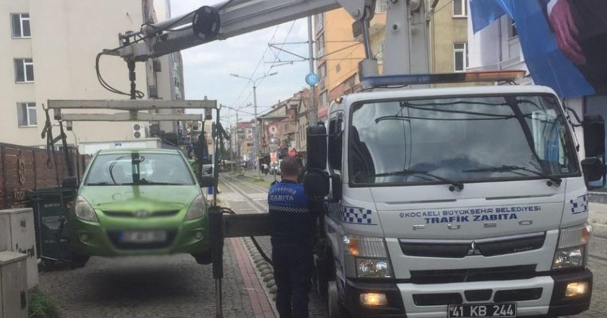 Tramvay yoluna park edilen araçlar çekiliyor